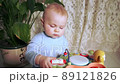 concentrated baby sits and plays with educational toy 89121826