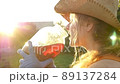 Beautiful girl in a hat drinks juice from a jar 89137284