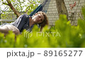 Beautiful girl with curly hair lies in a hammock in warm summer weather 89165277