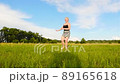 Beautiful girl circles on green field in summer time 89165618