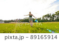 Young woman with blonde hair spinning on green field 89165914