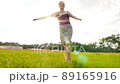 Beautiful blonde spinning on green field and laughing funny 89165916