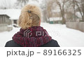 A girl with blond hair walks down the street in winter 89166325