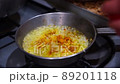 Fresh sliced onions sauteing in frying pan on stove top oven. Caramelized white onions cooking in silver saute pan. 89201118