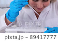 professional scientist takes a sample for a medical experiment. A research chemist works in a 89417777