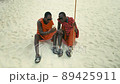 Happy Maasai Tribe Men Sitting on the Sand in the Desert Watching Smartphone and Showing Thumb Up Sign. 89425911