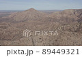 Drone view from high up showing wide, expansive view of a dry, dusty mountain range, canyons and valleys below 89449321