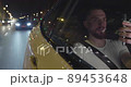 Young man taxi passenger holding his cellphone and starting a video call 89453648