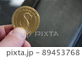 The hand holds a golden dollar coin. Successful business. 89453768
