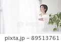 Pregnant woman standing by the window with a smile 89513761
