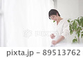 Pregnant woman standing by the window with a smile 89513762