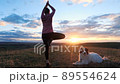 woman doing yoga under sunset sky 89554624