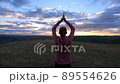 woman doing yoga under sunset sky 89554626
