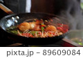 Close-up of chef is tossing ingredients in frying pan 89609084