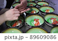The cook is decorating many same dishes with herbs 89609086