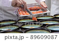 The chef lays out salmon in many same dishes 89609087
