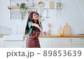 Asian young woman dancing in kitchen room. Female happy and relaxing at free time on weekend 89853639