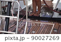 A girl washes the deck on a yacht 90027269