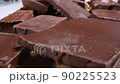 extreme close-up detailed broken pieces of bittersweet chocolate with whole hazelnuts 90225523