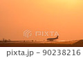An airplane gliding through Kumamoto Airport against the backdrop of the sunset 90238216