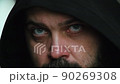 A man with a beard in the hood looks sadly at the camera, static camera, close-up of the face 90269308