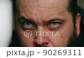 A man with a beard looks sadly at the camera and rubs his eyes with his hands, static camera, close-up of the face 90269311
