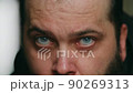 A man with a beard looks sadly at the camera, static camera, close-up of the face 90269313
