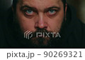 A man with a beard puts on a hood and looks sadly at the camera, static camera, close-up of the face 90269321