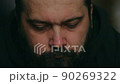 A man with a beard looks sadly down after at the camera, static camera, close-up of the face 90269322