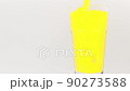 Pour orange juice into a rotating glass on a white background. 90273588