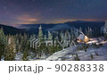 Snow covered mountain in winter, sky view and snowfall, sky changing from yellow hues at dawn to blue hues at noon 90288338