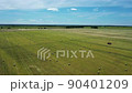 Aerial view of hayfield. Beautiful dynamic landscape with hay bales. Haystacks lay upon agricultural field taken on drone. Agriculture concept. 90401209