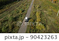 Truck driver without cargo is driving on road through a picturesque forest area. Aerial motion forward 90423263