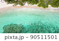Beautiful 4K tropical beach aerial - a bird's eye view of ocean waves crashing against an empty beach from above 90511501