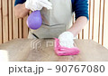 Restaurant worker is cleaning the dining table using a spray of alcohol and a clean cloth, Eliminate germs or viruses for restaurant hygiene, Using cleaning solutions or using alcohol to kill germs. 90767080