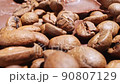 Extreme close-up of detailed coffee beans and bittersweet chocolate chunks with whole hazelnuts 90807129