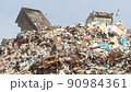 Dump trucks dump garbage in a huge pile 90984361