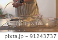料理中に調味料・塩をふっている女性 91243737