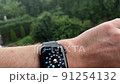 Smart watch on a man's hand, it's raining, shows the weather 91254132