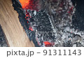 Oak firewood in the smokehouse, close-up view. The process of smoking meat 91311143