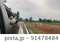 The Dog looks out the open window of the car. 91478484