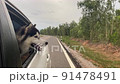 The Dog looks out the open window of the car. 91478491