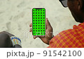 Masai Tribe Men Looking at the Smartphone and Touching Green Screen in the Front of Desert 91542100