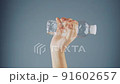 female hand squeezes an empty plastic bottle 91602657