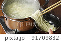 茹でたうどんの麺をどんぶりに取るところ 91709832