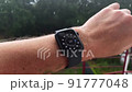 Smart watch on a man's hand, it's raining, shows the weather 91777048
