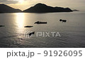 Aerial view moving fishing boat at the ocean. Top view sailing fishing boat. Ocean sea water wave reflections. Fishing boat trawler catch fish and sailing on sea at sunrise. Khanh Hoa, Vietnam 91926095