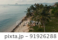 Tent and car on sea shore. Asia couple with beach accessories and car near beach under coconut tree, aerial view. Summer trip. Camping tent having relax time and enjoying adventure travel lifestyle 91926288