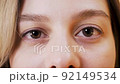 Close-up of large and beautiful green female eyes, calm blinking 92149534