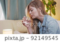 Close-up of a young beautiful woman takes a pill and drinks water from a glass 92149545